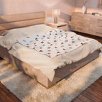 rose gold heart plush blanket displayed on a cozy bed in a softly lit bedroom setting.
