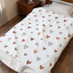 rose gold heart plush blanket on a bed, featuring a hand-drawn heart pattern in warm tones.