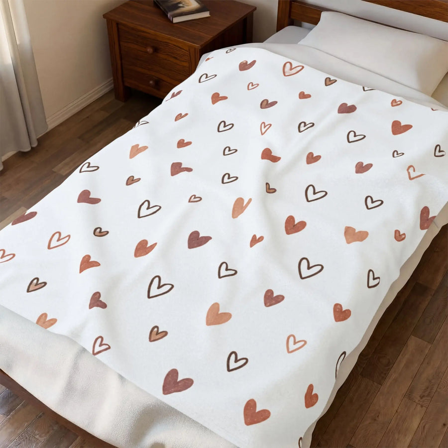 rose gold heart plush blanket on a bed, featuring a hand-drawn heart pattern in warm tones.